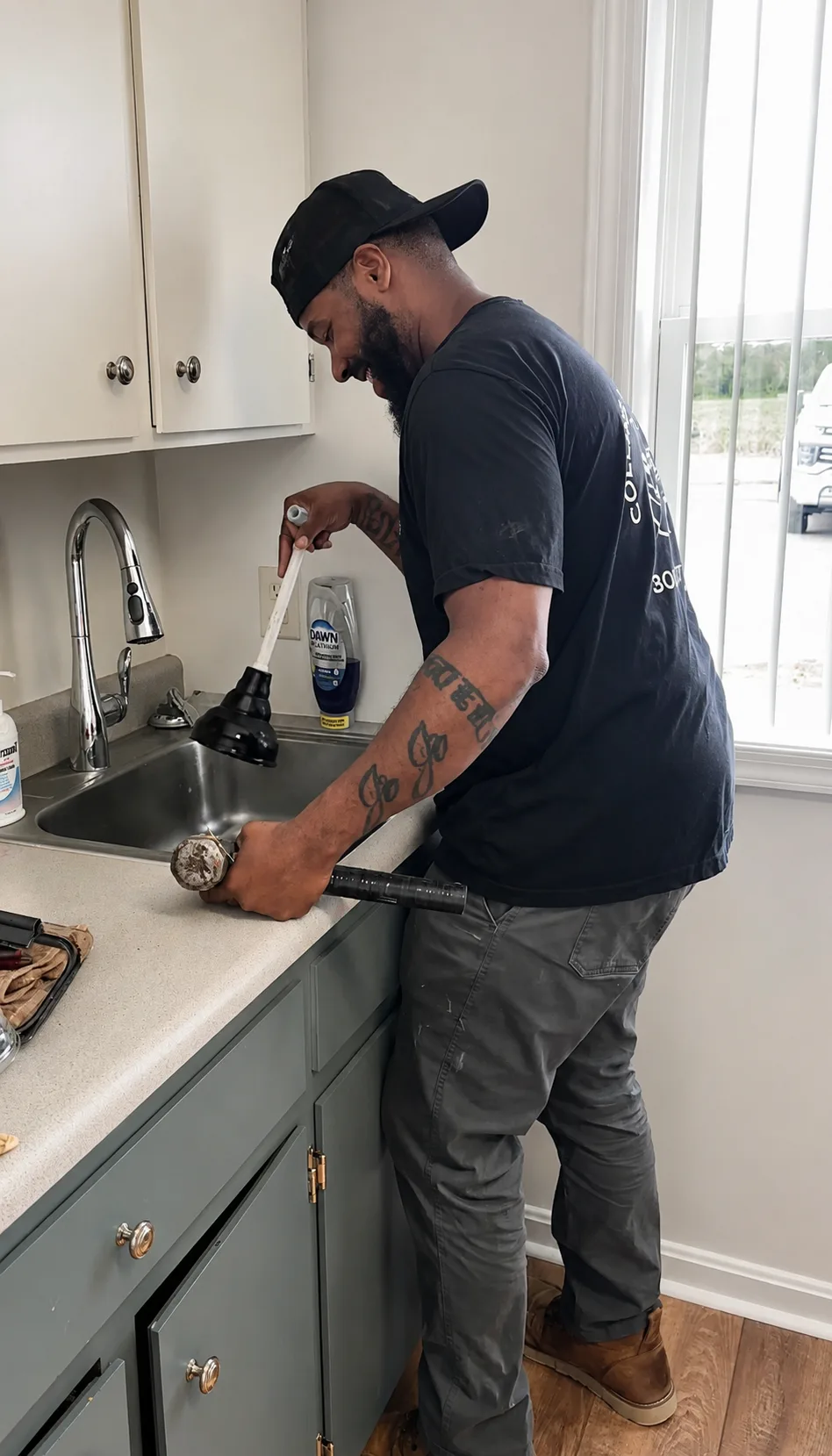 Collins Mechanical plumber clearing a kitchen sink drain